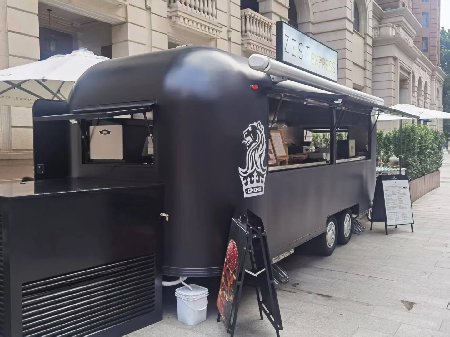 酒店外的 ZEST EXPRESS 黑色餐车，带车顶招牌与售卖窗口